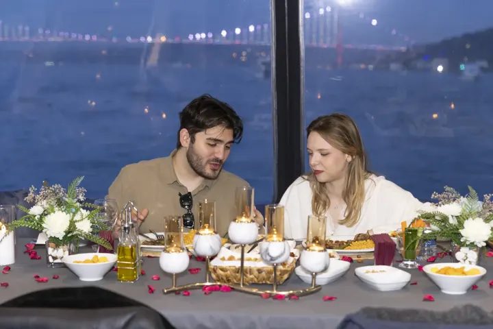 Boğaziçi Köprüsü ışıkları karşısında yatta romantik akşam yemeği yapan çift
