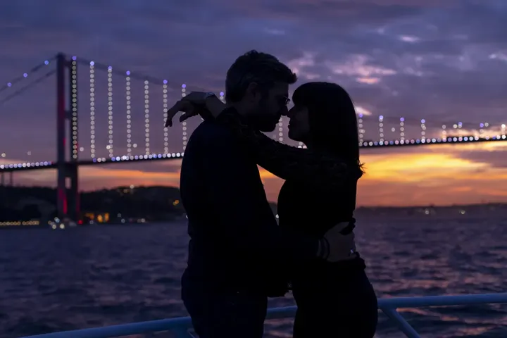 Gece Boğaziçi Köprüsü önünde yatta çift