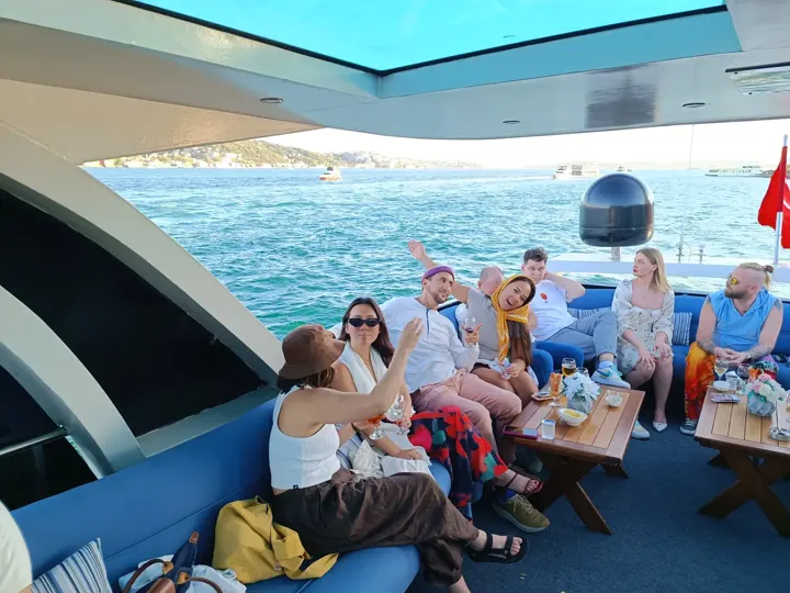 Panoramik tavanlı yat salonunda Boğaz turunda eğlenen arkadaş grubu