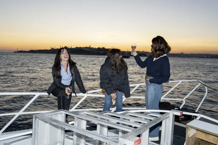 Boğaz'da gün batımında yatın pruvasında arkadaşlar