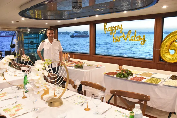 Happy birthday balonları ve açık büfe ile süslenmiş yat salonu, yatta doğum günü