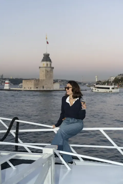 Kız Kulesi önünde yatın pruvasında oturan misafir