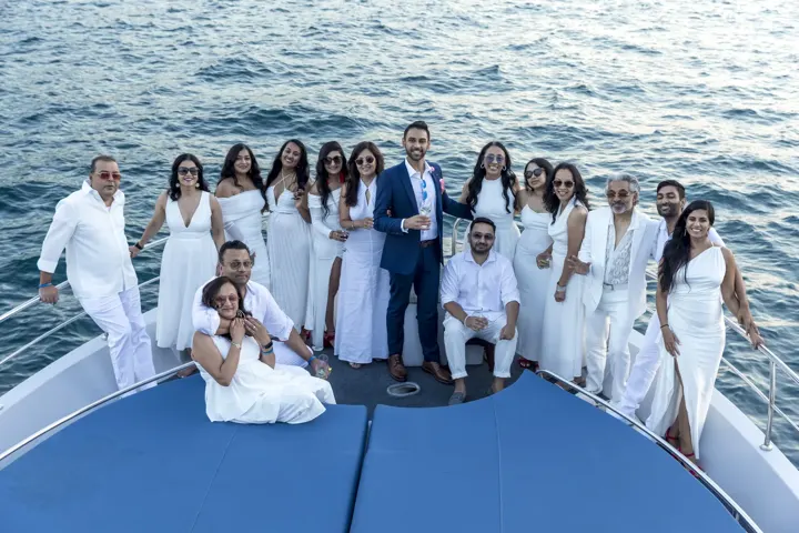 Beyaz kıyafetli şirket ekibi yatın pruvasında toplu fotoğrafta, kurumsal yat etkinliği
