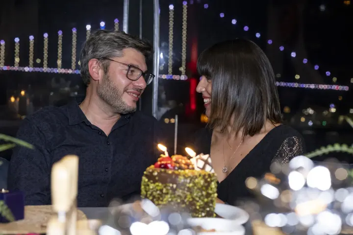 Yatta doğum günü pastası ve çift, arkada ışıklı köprü